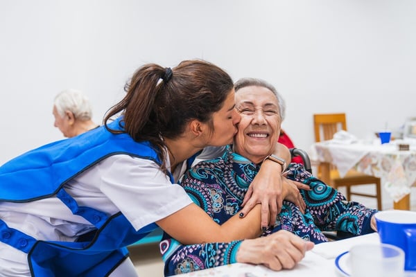 caregiver-sharing-joyful-moment-with-elderly-woman