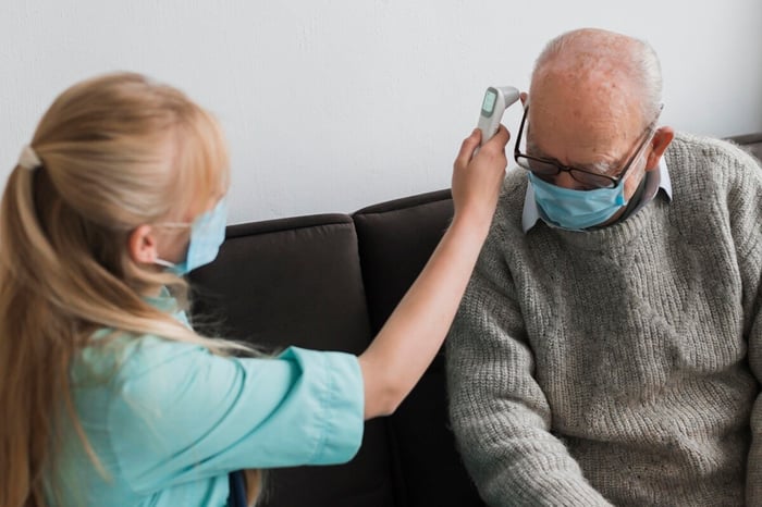female-nurse-checking-old-man-s-temperature