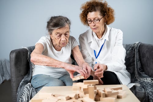 mujer-construye-torre-bloques-madera-ayuda-medico