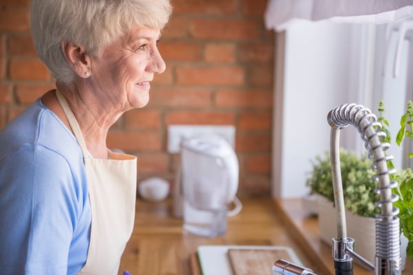 senior-woman-looking-through-kitchen-window