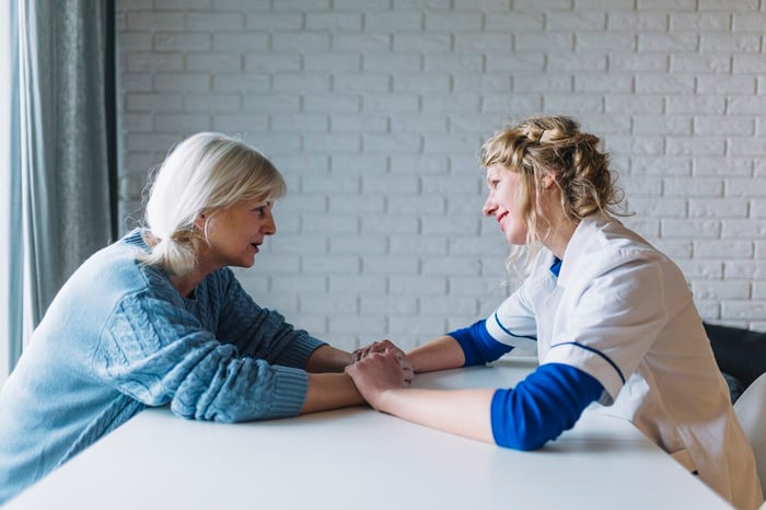 side-view-woman-talking-nurse-nursing-home