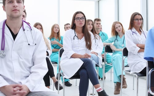 top-view-group-smiling-doctors-pointing-you